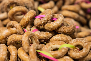 A large quantity of pretzels hanging on a string. Close-up shot of a pretzel. A lot of bagels..