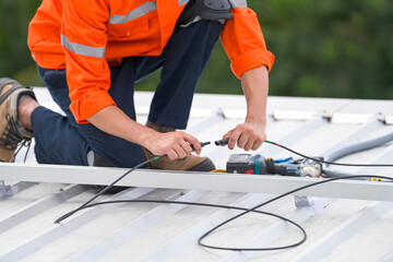 Men technicians mounting photovoltaic solar moduls on roof of house.