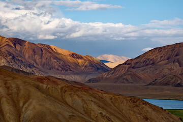 Tajikistan. A picturesque sunset in the valley of the mountainous desert lake Bulunkul on the northeastern section of the Pamir tract.