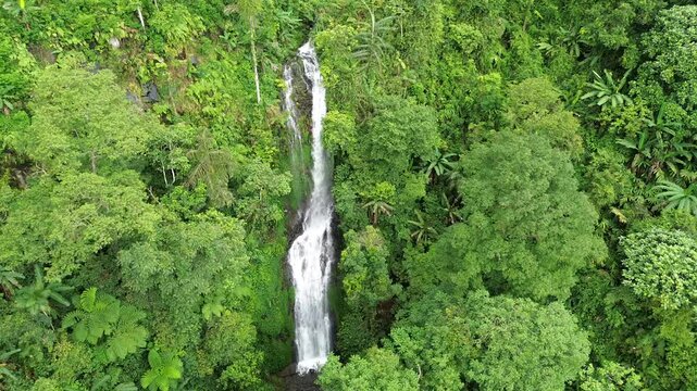 Aerial shot of Curug Cijalu ,beautiful hidden waterfall in green forest. Tropical mountain jungle waterfall in the tropical forest. Nature background
