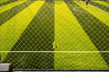 The synthetic grass lines on the mini soccer field form a symmetrical pattern. suitable for a green field sports concept wallpaper background © InveStock