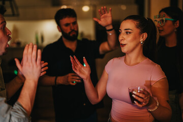 A group of friends joyfully celebrating a birthday party indoors, engaging in animated conversation and enjoying a festive atmosphere. Warm lighting and smiling faces enhance the celebratory mood.
