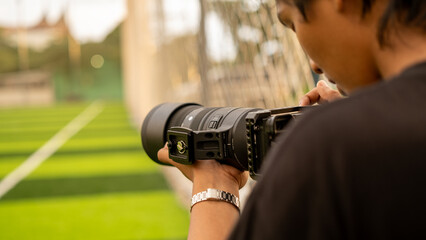 a photographer using a telephoto lens is focusing on documenting the sport of mini football on the...