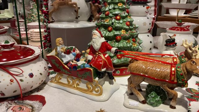 A lot of New Year's porcelain toys in a vintage style, Santa Klaus, snowman, plates and a deer in a supermarket on the Christmas Sale. Bijenkorf.