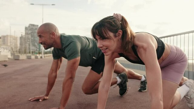 Close-up side view of happy multi-ethnic couple training outdoors, doing crossfit outside