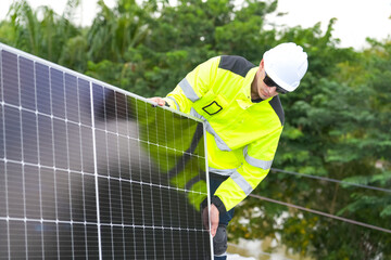 Men technicians mounting photovoltaic solar moduls on roof of house.