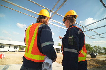 Two surveyor of construction engineer, architect, in hardhat working on construction site.