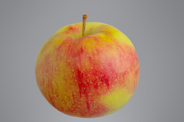Red apple with yellow isolated on gray background.