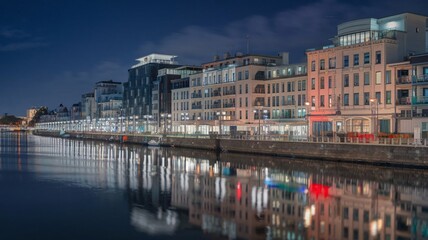 Night View of Busy Waterfront Promenade with Glowing City Reflections