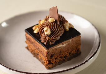 Chocolate cake with glaze, cream, and nut topping, served in portioned slices