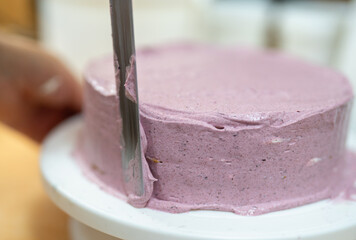 The process of making a cake finishing a round cake with cream