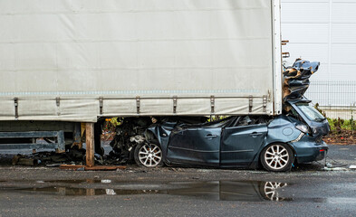 a car smashing into the rear of a parked semi trailer and entered completely under