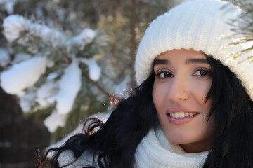 portrait of beautiful young woman with long hair during the day in the forest in winter