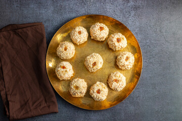 Moa is a traditional Bengali sweet made of puffed rice, jaggery, and coconut, often shaped into small, round balls.