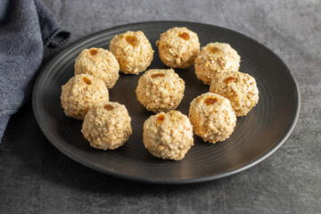 Moa is a traditional Bengali sweet made of puffed rice, jaggery, and coconut, often shaped into small, round balls.