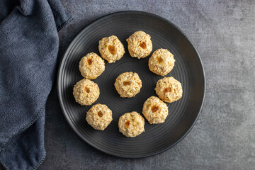 Moa is a traditional Bengali sweet made of puffed rice, jaggery, and coconut, often shaped into small, round balls.