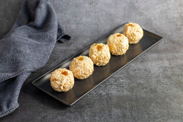 Moa is a traditional Bengali sweet made of puffed rice, jaggery, and coconut, often shaped into small, round balls.