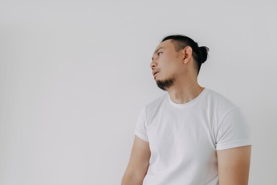 Shrug whatever face Asian man in white t-shirt isolate on white.
