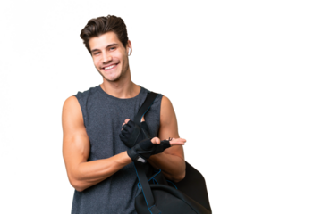 Young sport caucasian man with sport bag over over isolated background presenting an idea while looking smiling towards