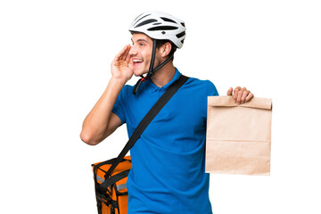 Young caucasian man taking a bag of takeaway food over isolated background shouting with mouth wide open to the side