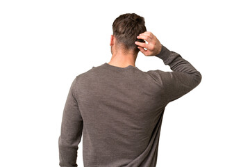 Young handsome caucasian man over isolated chroma key background in back position and thinking