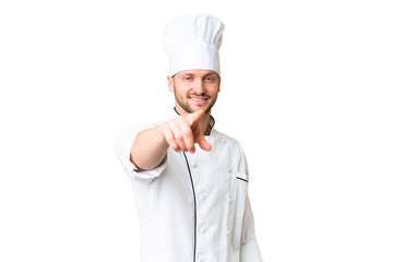 Young caucasian chef over isolated chroma key background points finger at you with a confident expression