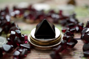 A small black pyramid with jewelry and coins.
