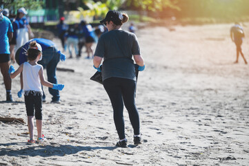 Community volunteers clean beach with children during environmental project