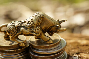 A bull statuette with coins. Finance and economics.