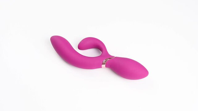 Pink vibrator spinning on white background.