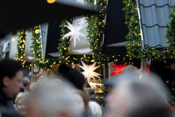 viele Besucher auf einem Weihnachtsmarkt mit Weihnachtsstern