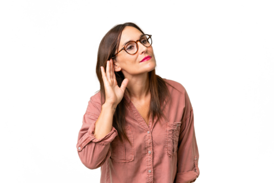 Middle-aged caucasian woman over isolated background listening to something by putting hand on the ear