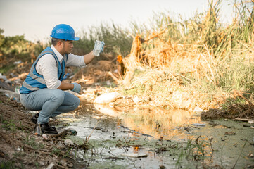 Water resources engineers inspect the quality of a canal in a community filled with garbage.