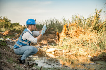 Water resources engineers inspect the quality of a canal in a community filled with garbage.