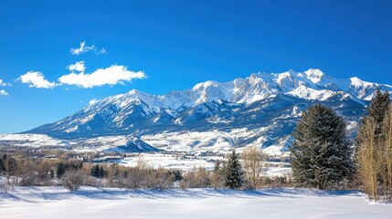 Fototapeta premium Majestic Snow-Covered Mountains Against a Clear Blue Sky in Winter, Capturing the Beauty of a Serene Snowy Landscape in North America