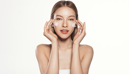 Fototapeta premium Close up of beauty natural woman, clean and fresh skin tone, playful eyes, apply facial skincare cream with anti-aging detoxifying effect, moisture and nourish skin, white background