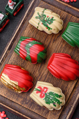 Sweet madeleine sponge cookies covered with colored chocolate