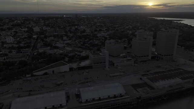 Drone flies to the left over port and into historic city center with a failing sunset in Asuncion, Paraguay