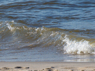 Gentle Waves Crashing on a Sandy Beach with Sparkling Water Reflections