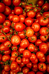 Vibrant red tomatoes bursting from large box, still attached to stems