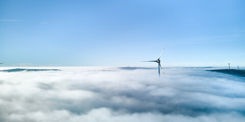 Windkraftanlage im Wolkenmeer und Gegenlicht