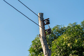 Power line on wooden pole against clear sky.