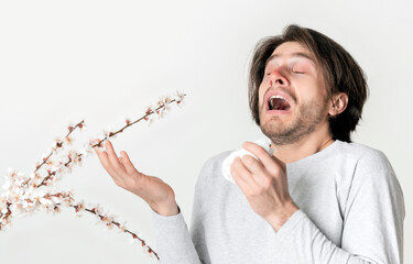 Guy sneezes from seasonal allergy to flowering plants, free space