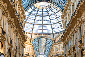 Ornate facade of Galleria Vittorio Emanuele II in Milan, Italy. Oldest Italian shopping mall neoclassical architecture with grand glass dome and decorative details in Milano city