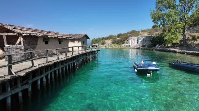 Wooden walkway and stilt houses recreate a bronze age settlement at Bay of bones archaeological site on lake Ohrid, Macedonia, showing prehistoric life and ancient building techniques