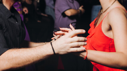 Couples dancing traditional latin argentinian dance milonga in the ballroom, tango salsa bachata kizomba lesson in red and purple lights, evening dance school class festival, performance rehearsal