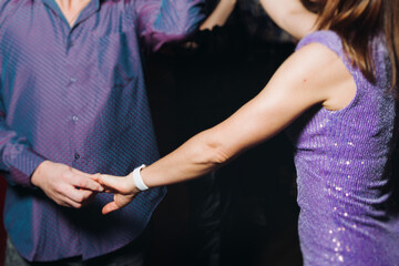 Couples dancing traditional latin argentinian dance milonga in the ballroom, tango salsa bachata kizomba lesson in red and purple lights, evening dance school class festival, performance rehearsal
