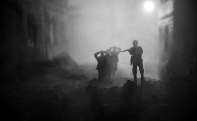 Military silhouettes fighting scene on war fog sky background. A German soldiers raised arms to surrender. Plastic toy soldiers with guns taking prisoner the enemy soldier.