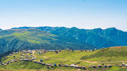Obraz premium Sunny view of green hills and a mountain village