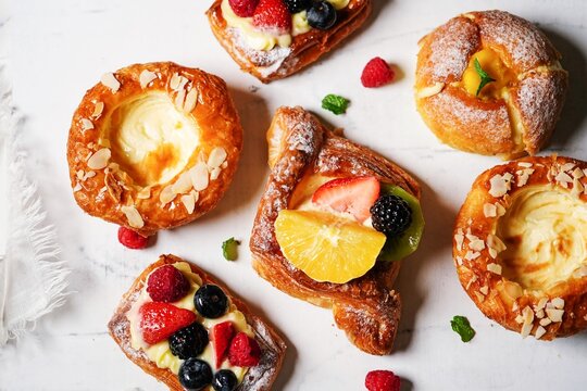 Assorted French Pastry tarts on white background, overhead view
